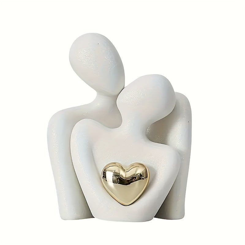 Ceramic sculpture of two figures embracing with a gold heart on a white background
