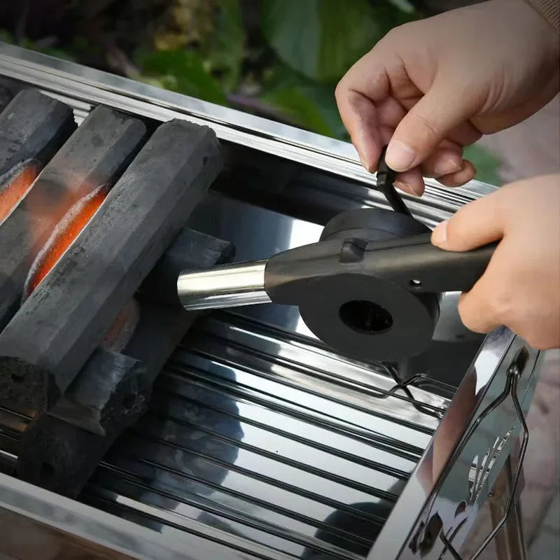 Person using a grill tool on a barbecue grill with a blurred background