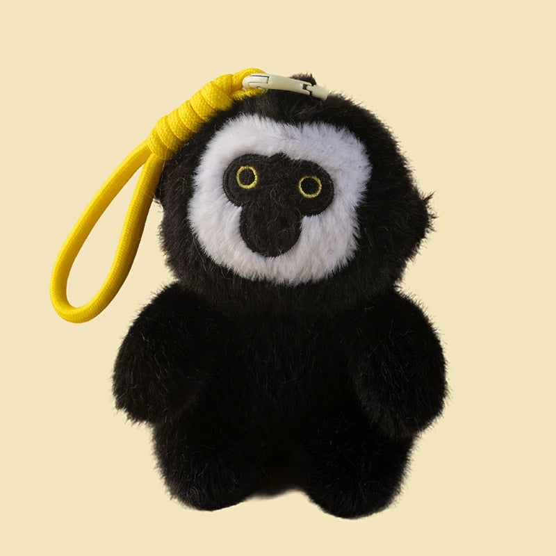 Plush monkey keychain with a yellow rope on a beige background