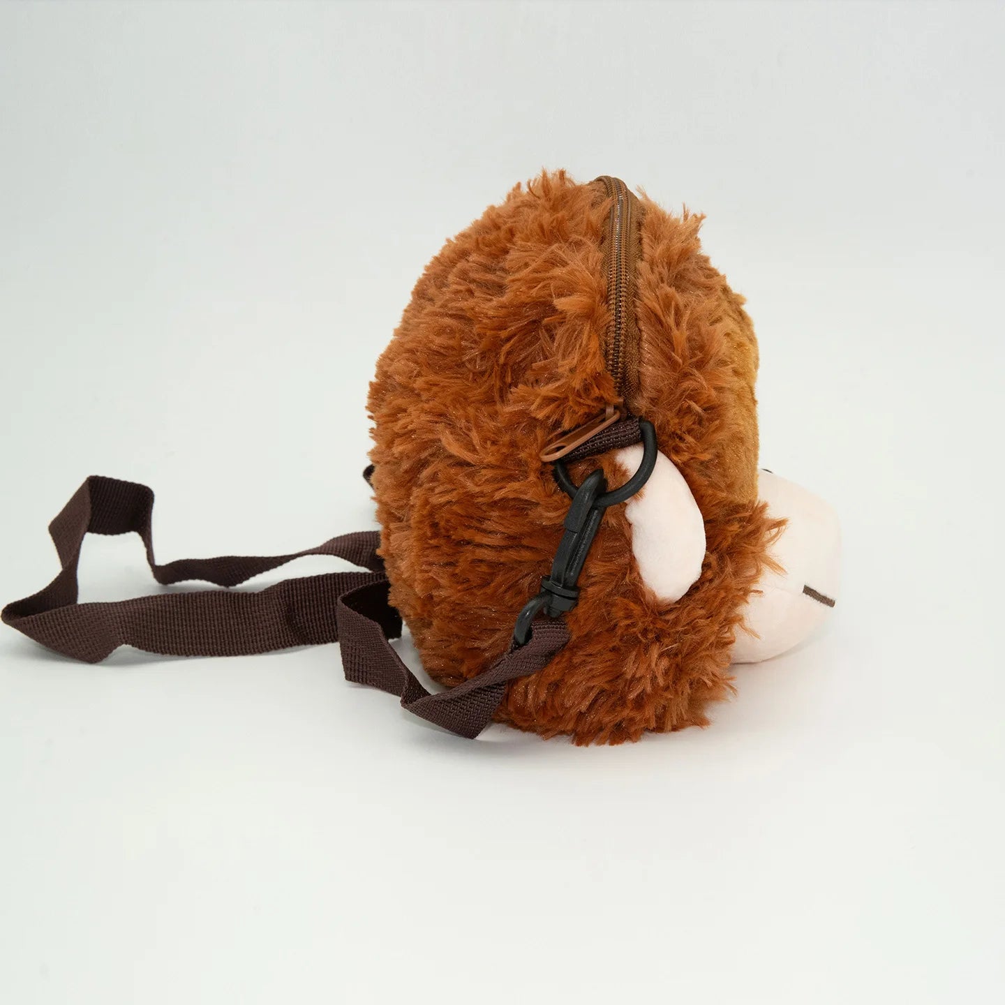 Brown plush dog toy with a strap on a white background