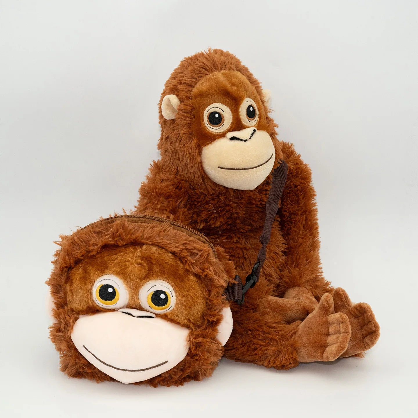 Two brown plush monkey toys on a white background