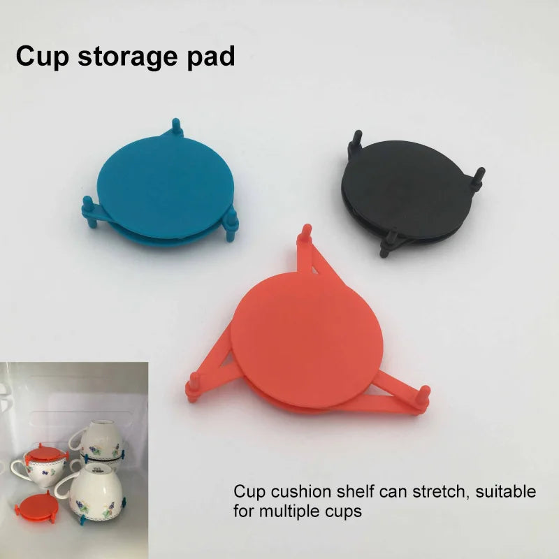 Three cup storage pads in blue, red, and black are displayed on a white background, with a small inset showing cups arranged in a holder. Text reads 'Cup storage pad' and 'Cup cushion shelf can stretch, suitable for multiple cups'.