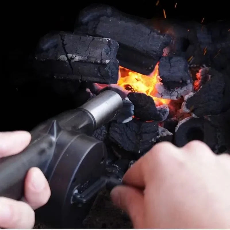 Person using a chimney starter to light charcoal briquettes.