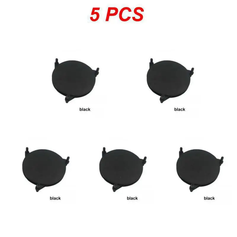 Five black circular objects with central holes on a white background